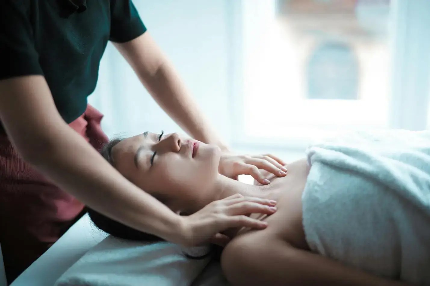 Woman receiving a calming neck and shoulder massage in a spa setting