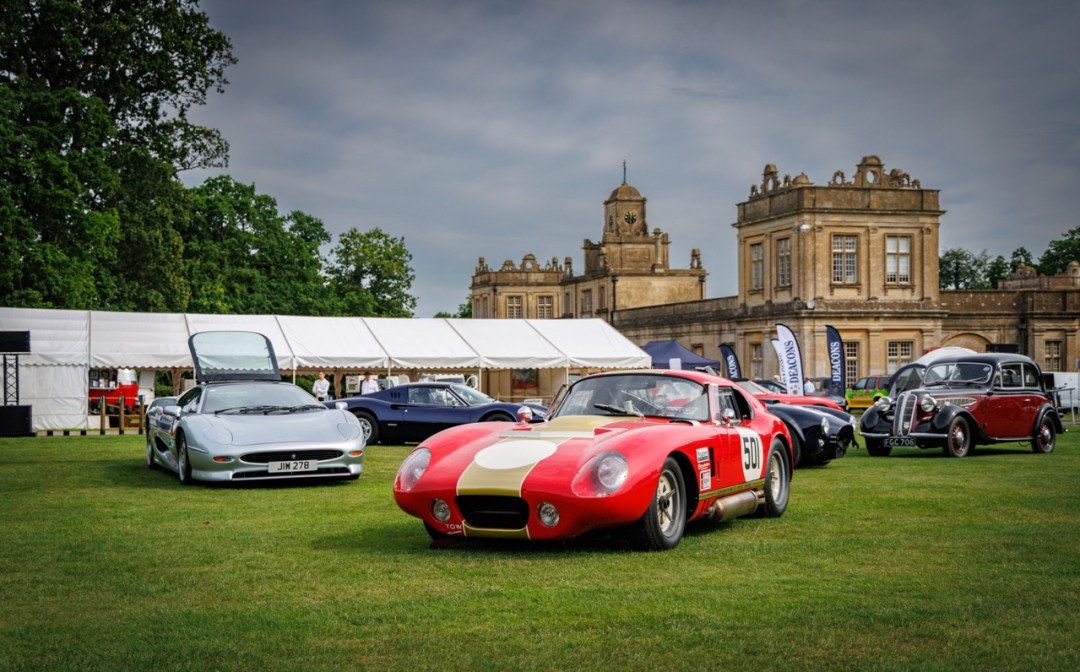 Historic competition car and performance vehicles displayed in front of Longleat House