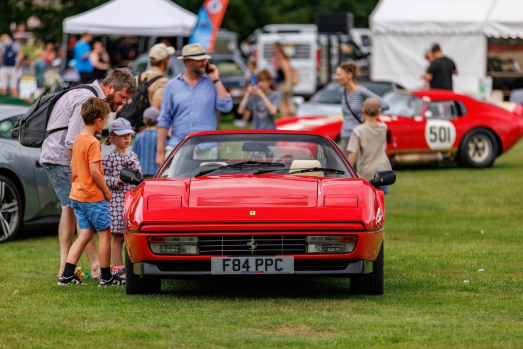 A family looking closely at a classic Ferrari during the Longleat motoring event