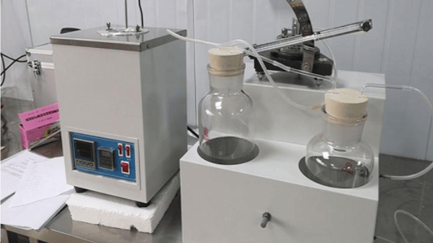 The image shows an immersion container holding rubber specimens in oils, fuels, or chemicals during ASTM D471 testing.