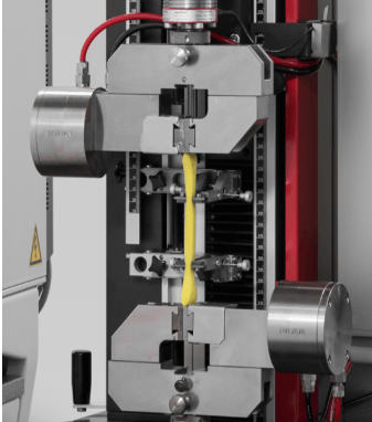 The image shows a universal testing machine for compression testing for quality testing according to ASTM D3574.