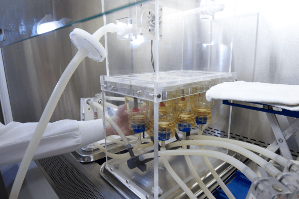 The image shows porous packaging material specimens, an exposure chamber, microbiological laboratory equipment, and technicians performing ASTM F1608 microbial resistance testing.