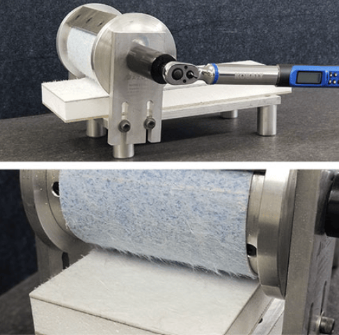 The image shows a climbing drum peel testing machine evaluating the peel resistance of an adhesive-bonded sandwich panel in accordance with ASTM D1781.
