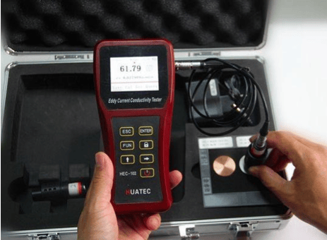The image shows an electrical conductivity tester measuring the conductivity of copper rods during ASTM B49 testing.