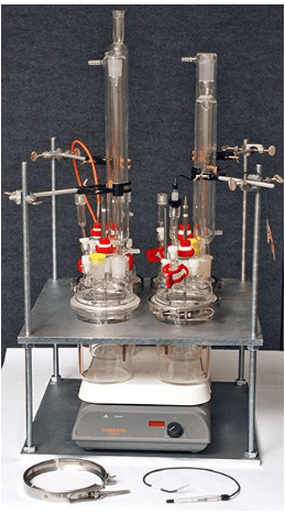 The image shows a laboratory galvanic corrosion test setup with dissimilar metal specimens connected and exposed to an electrolyte, following ASTM G71.