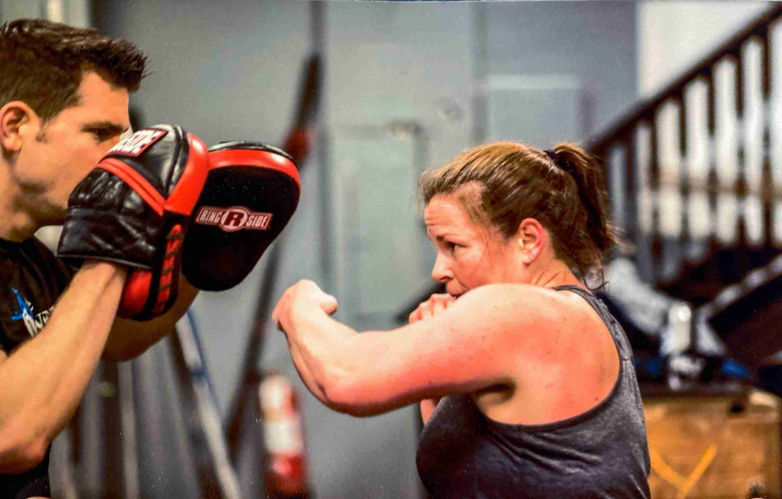 Matt holding pads for a woman punching