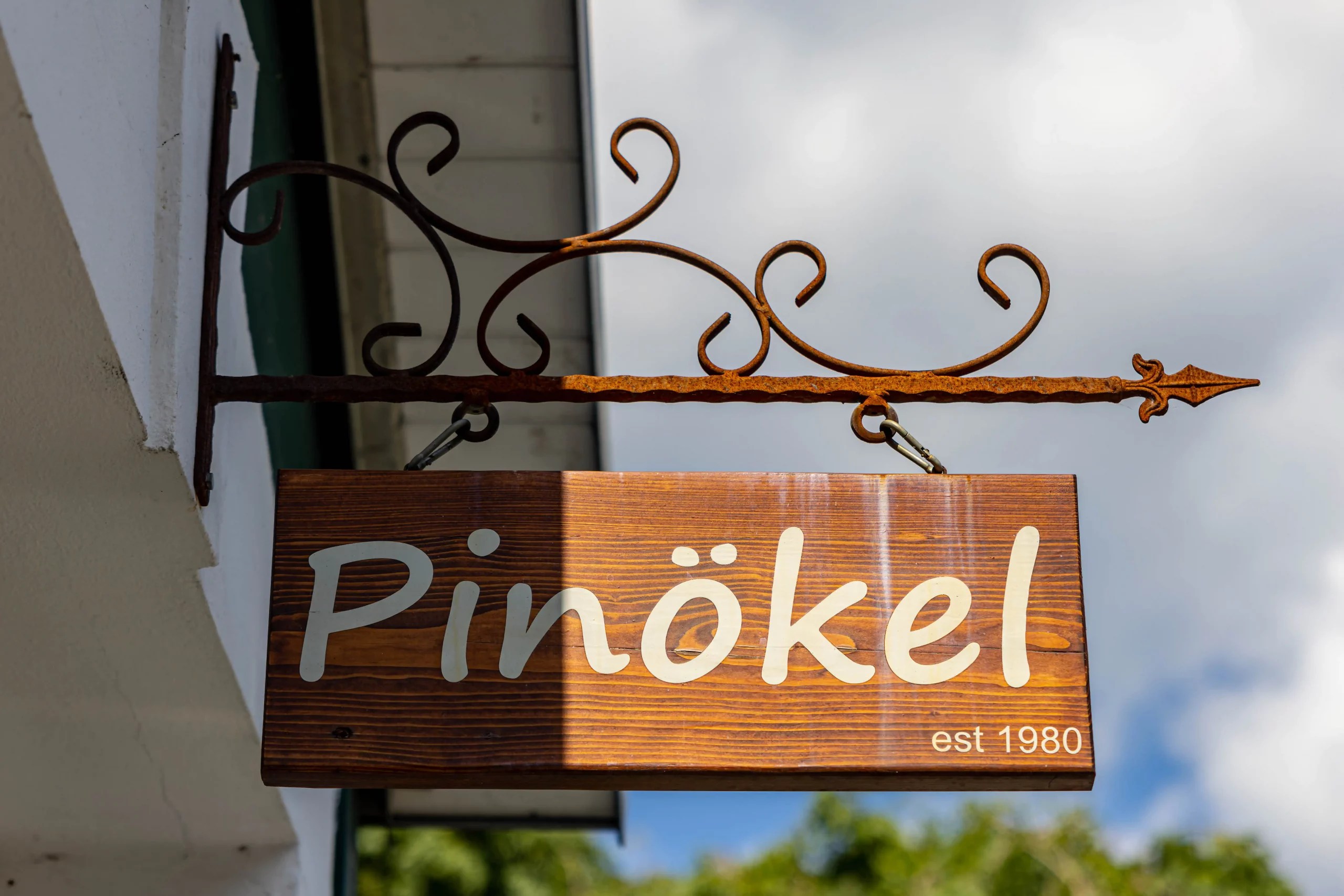 Holzschild einer Kneipe mit der Aufschrift "Pinökel est 1980"