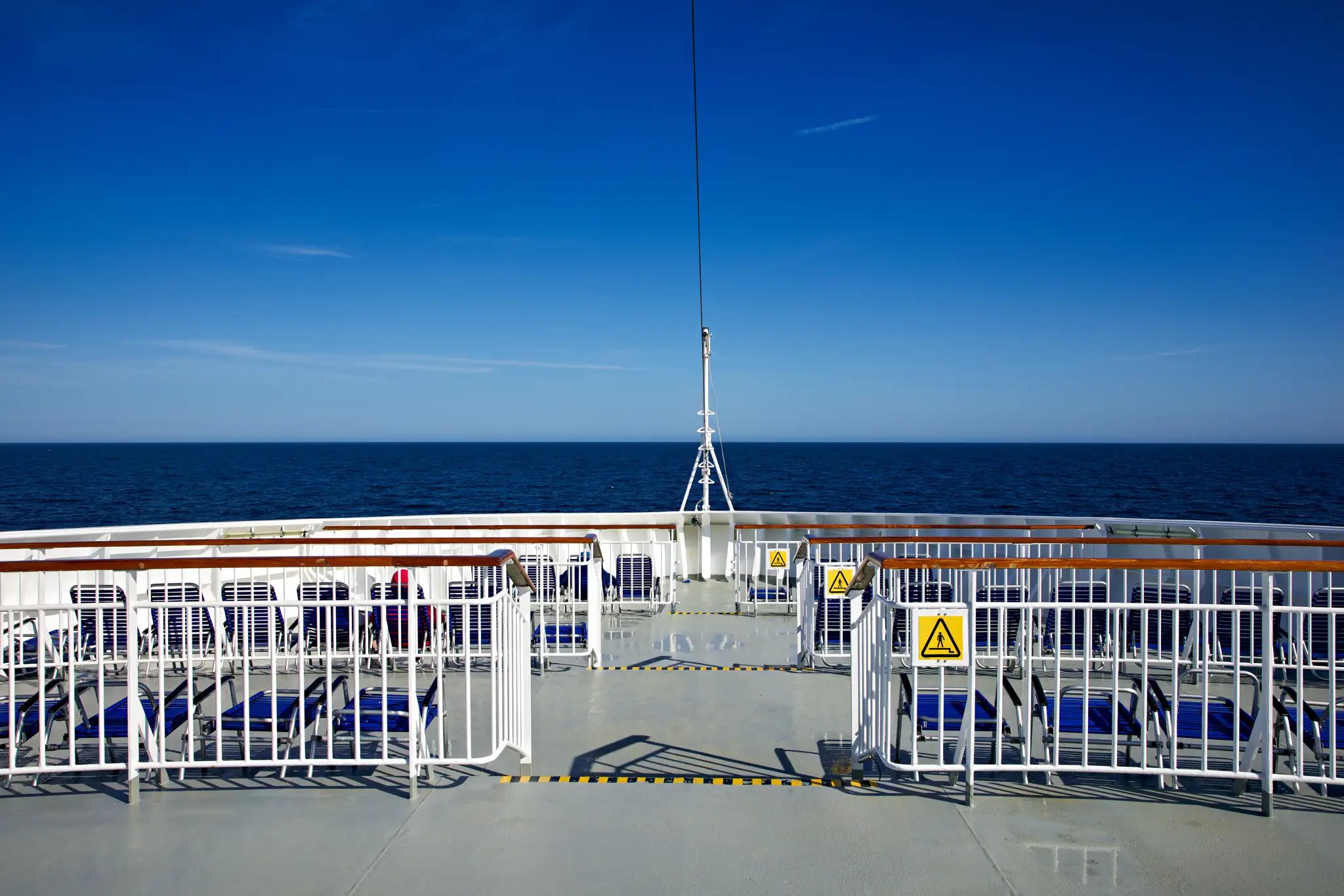 Blick vom Deck eines Hurtigruten-Schiffs auf das offene Meer unter klarem Himmel