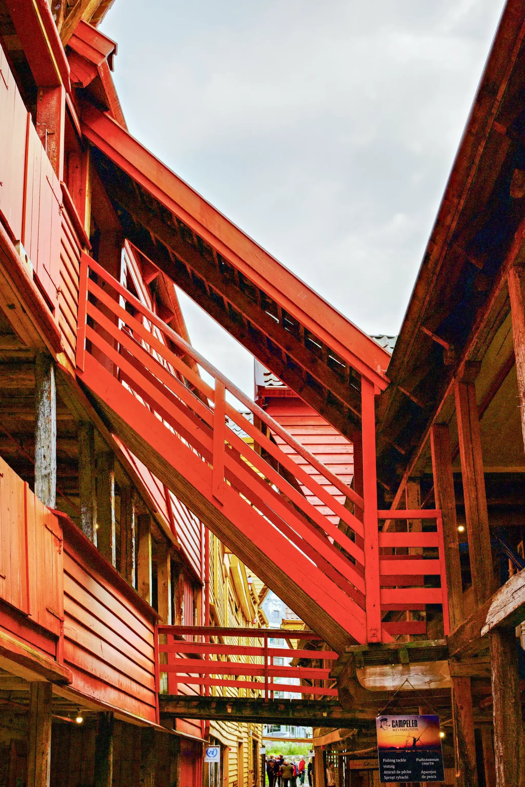 Rote Außentreppe zwischen traditionellen Holzhäusern in einem norwegischen Hafenort