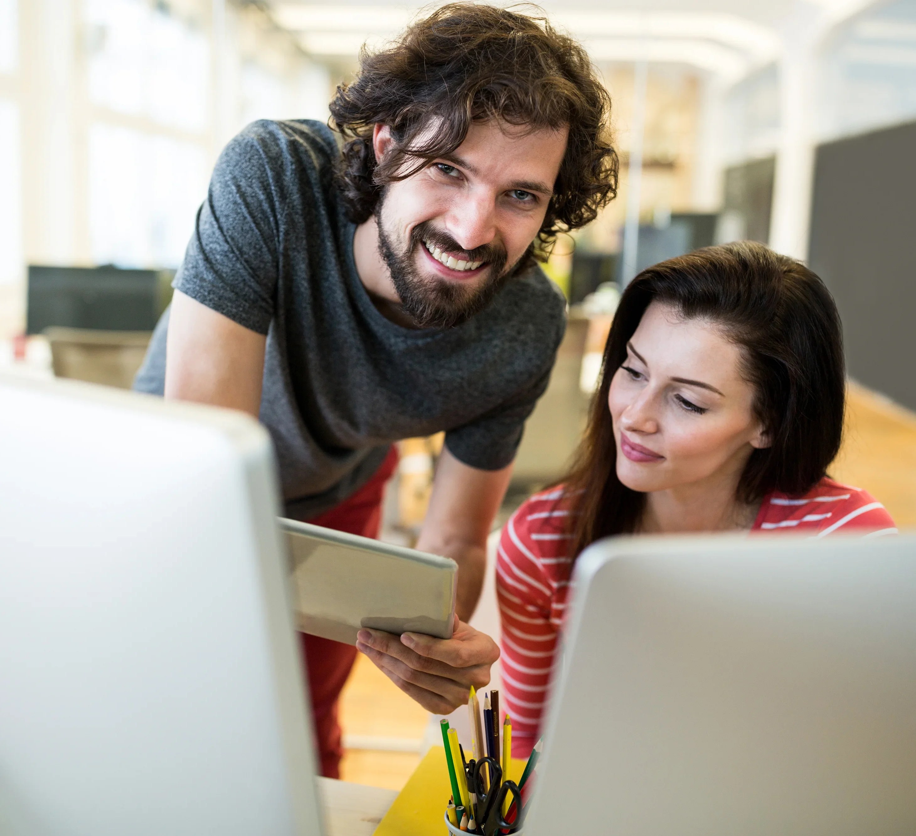 male and a female graphic designers using digital tablet and computers