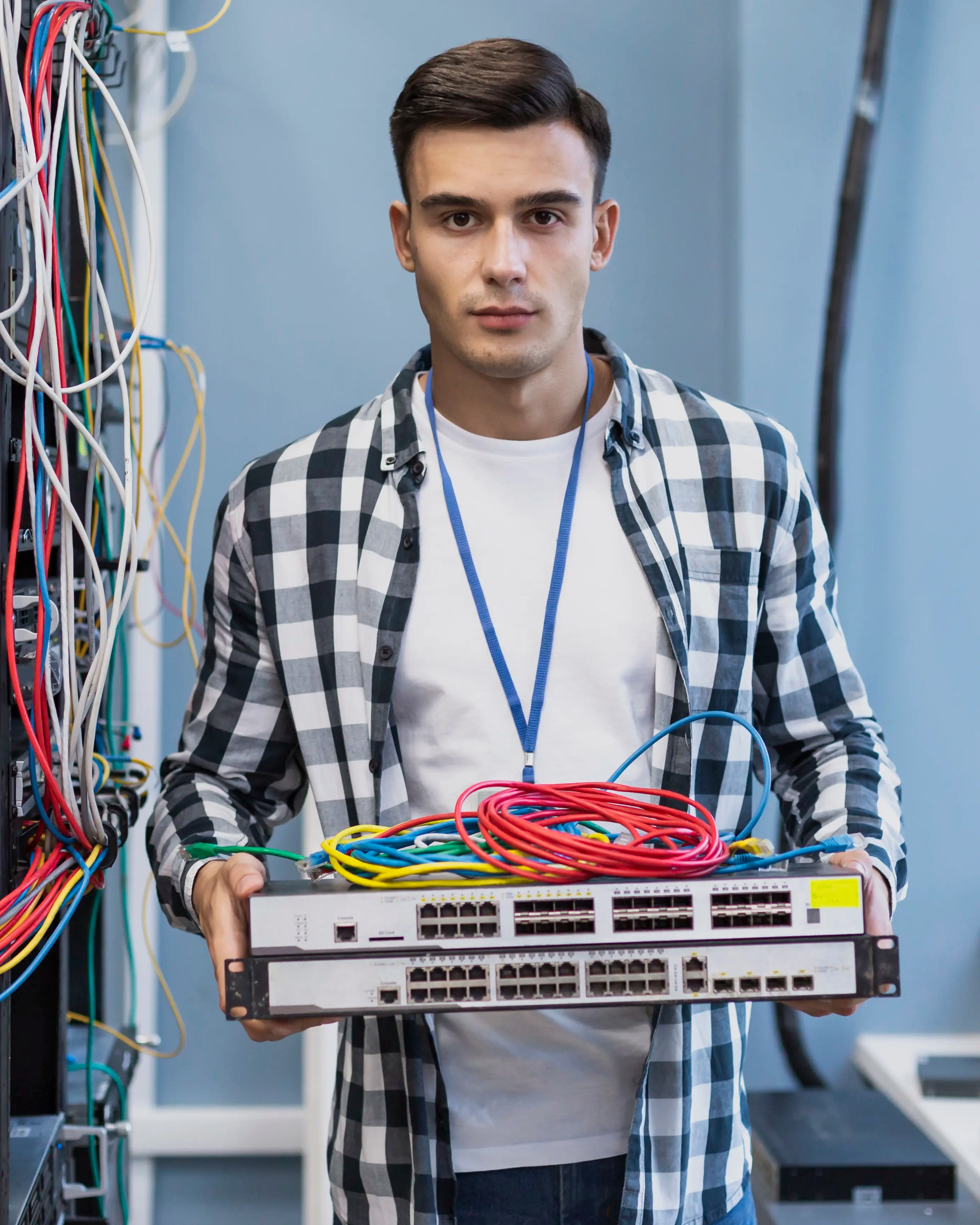 young man holding ethernet switches wires