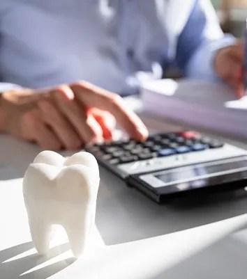 Calculator and dental model on a desk while reviewing accounts receivable