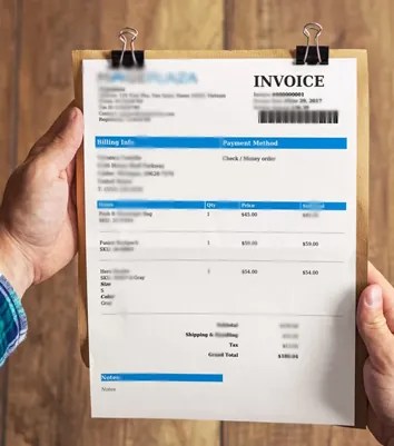 Hands holding a patient invoice on a clipboard