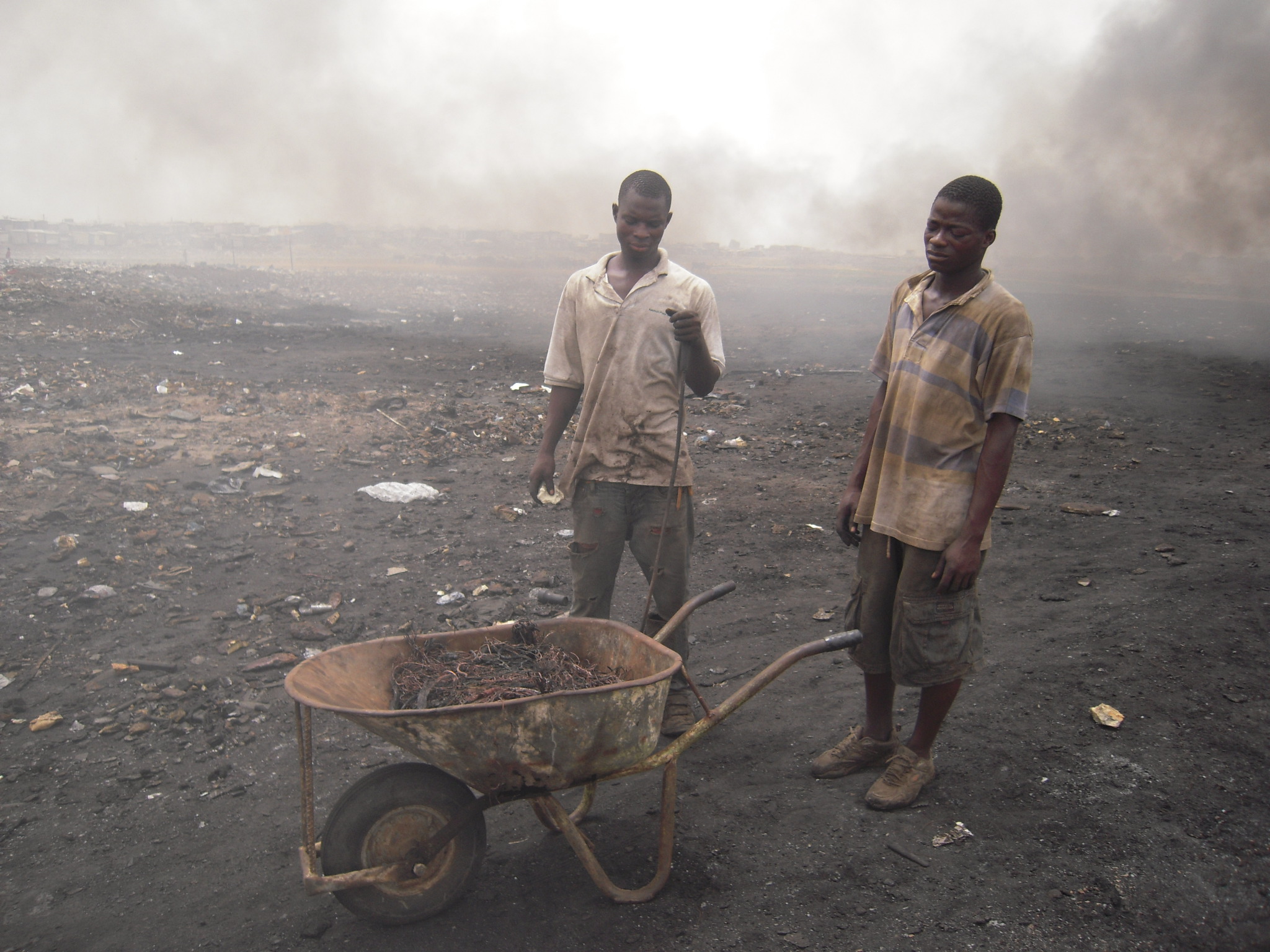 Workers processing electronic waste for copper recovery