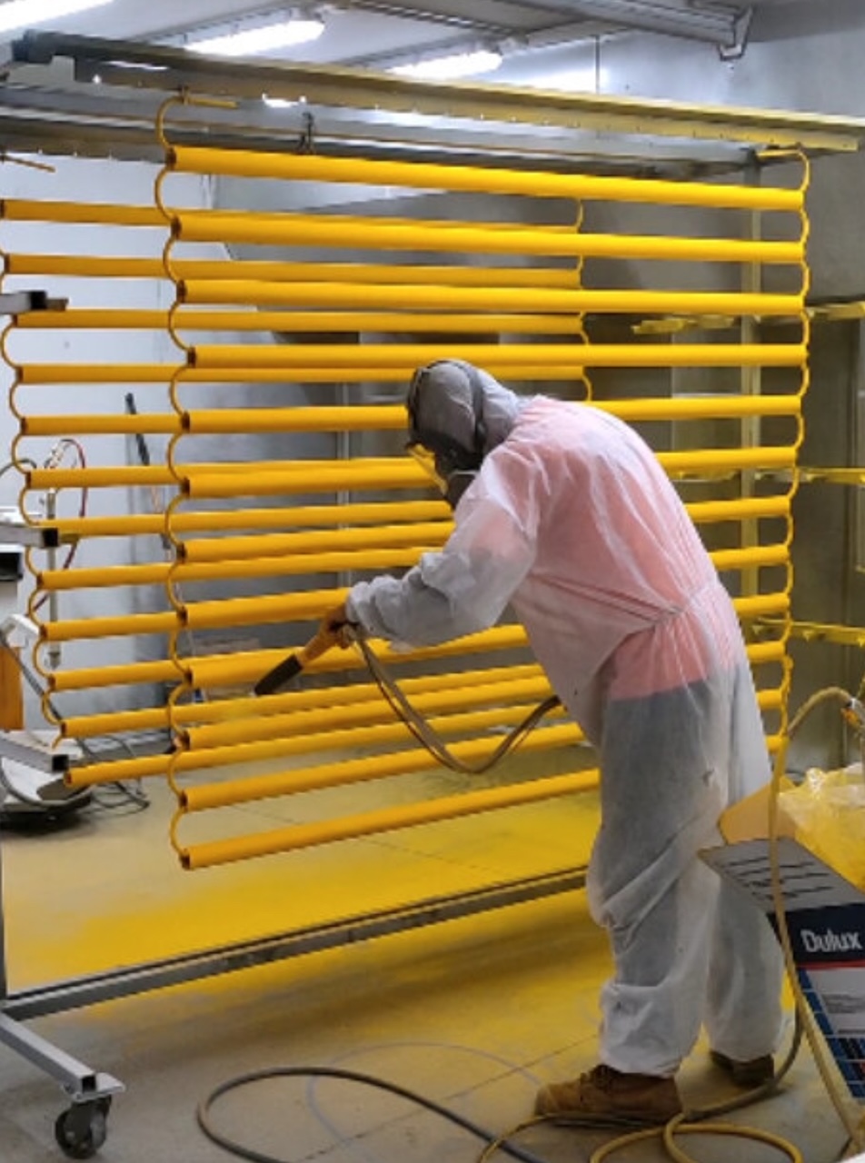 Powder coating applied to steel parts in a spray booth
