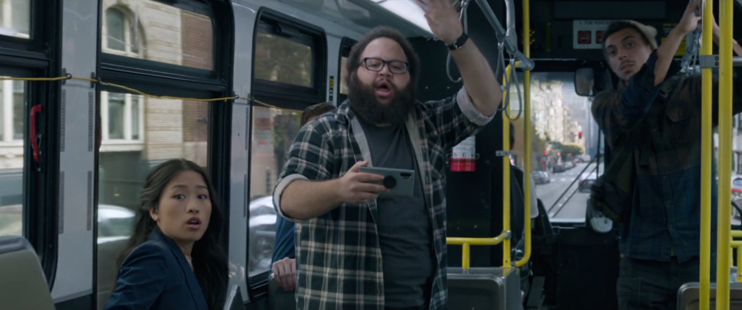 Onlookers watch a fight on a San Francisco metro bus.
