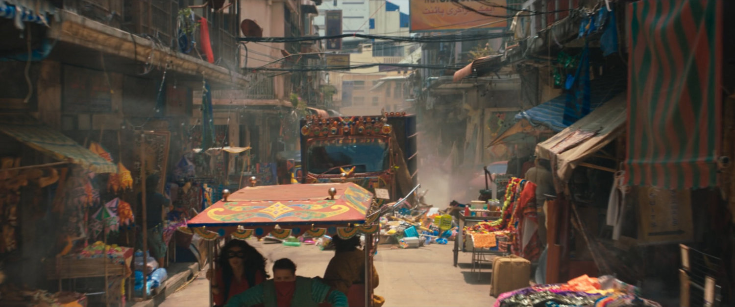 A Super Savari tourist bus driving through a crowded street.