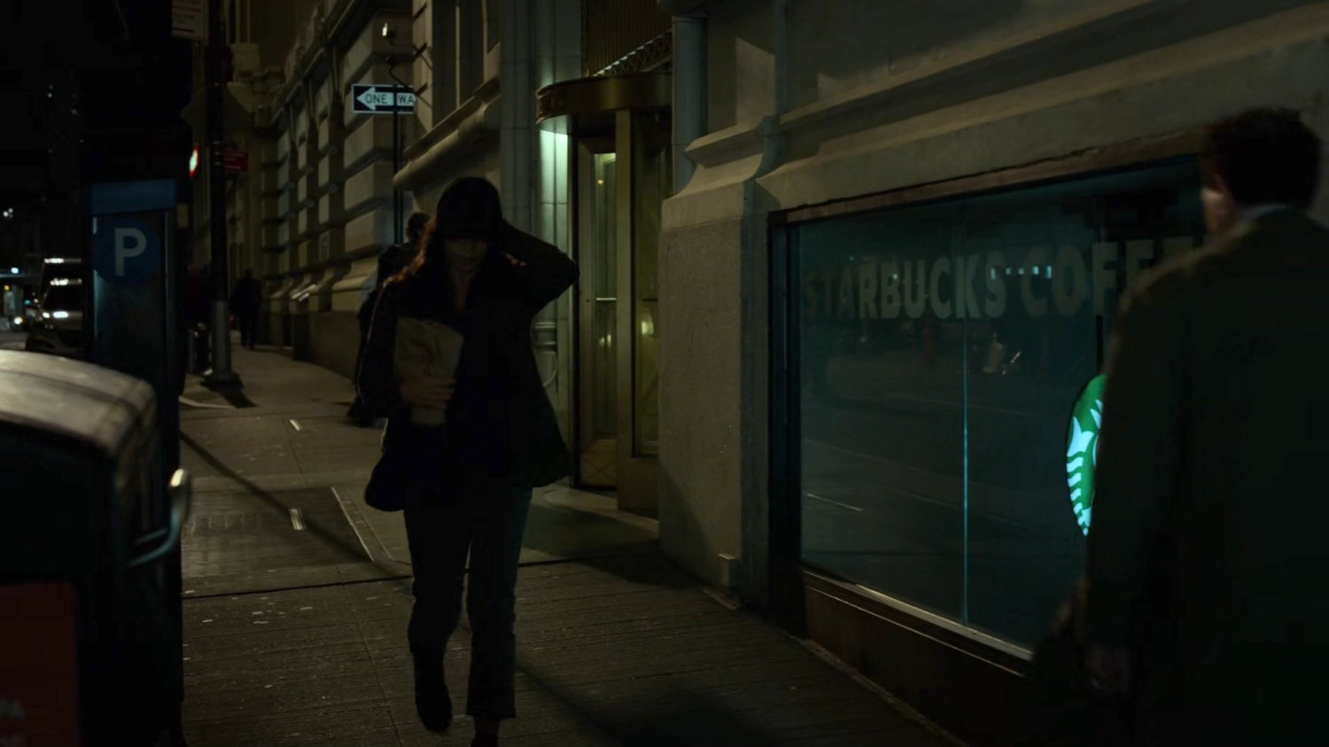 Claire walking along a sidewalk towards a peanut cart.