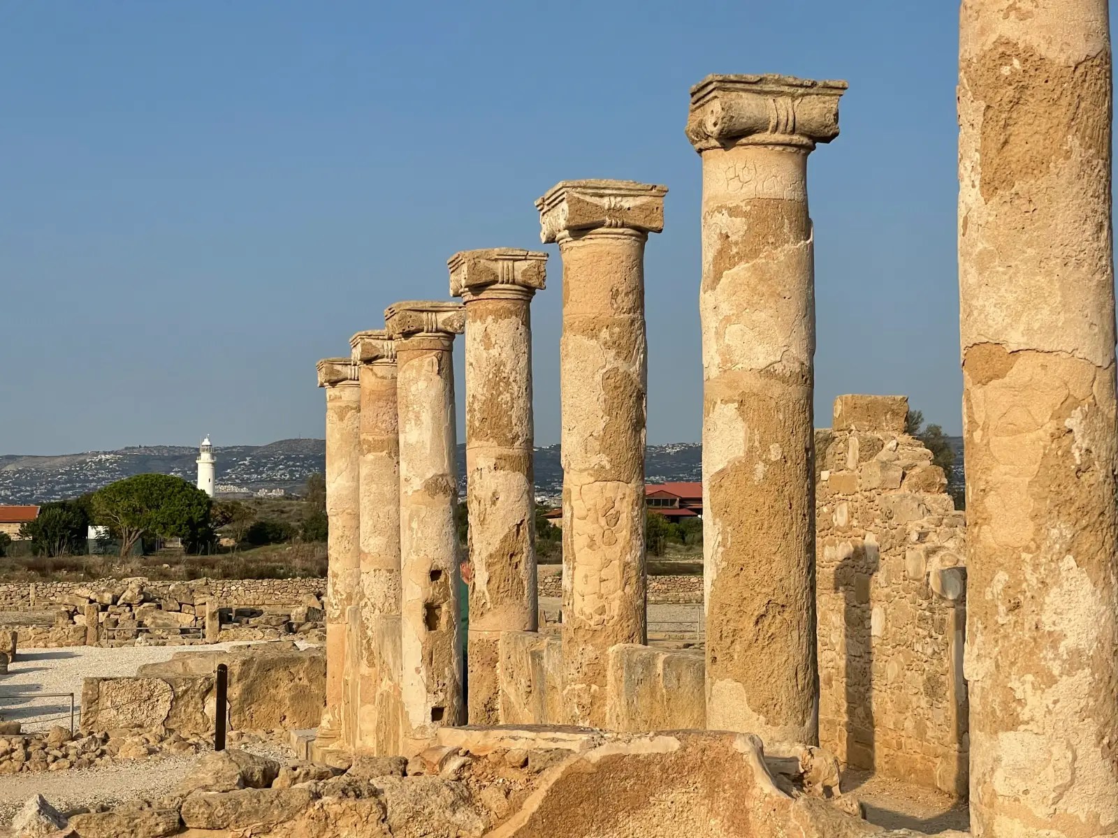 Ancient columns stand in a row pointing to a distant lighthouse