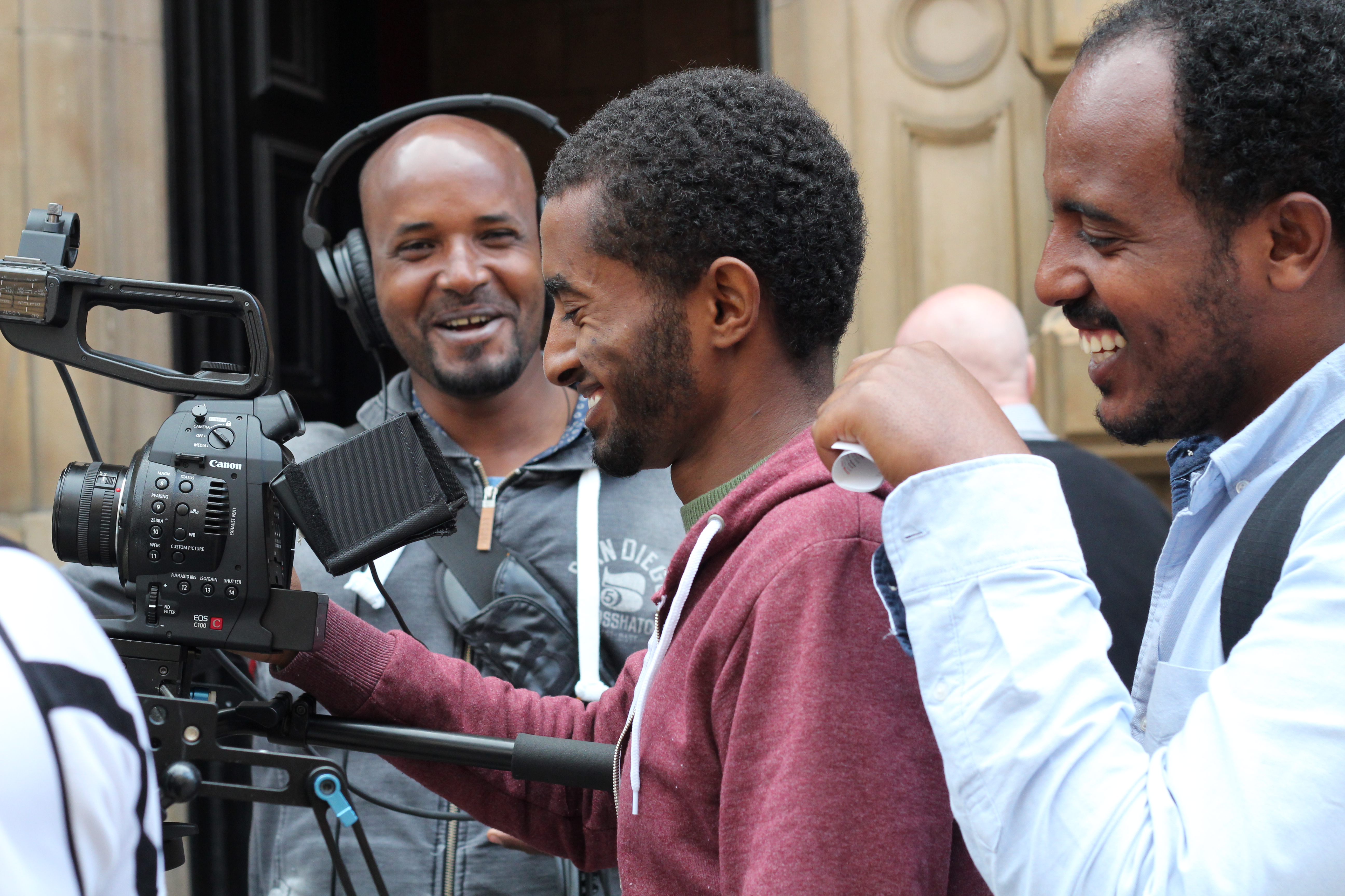 Three male participants filming and enjoying themselves with smiling faces