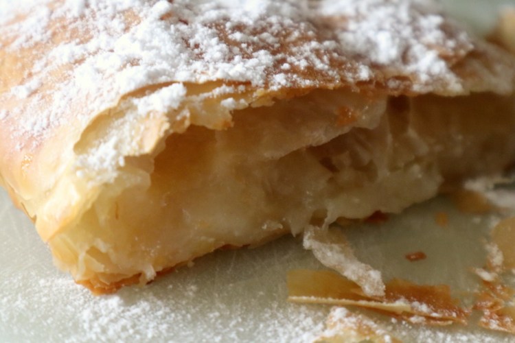 Bougatsa Rezept: So gelingt das traditionelle griechische Dessert 4 Ein Stück griechische Bougatsa mit Puderzucker und Zimt bestreut