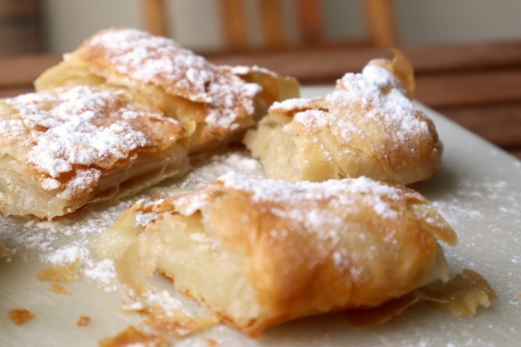 Bougatsa Rezept: So gelingt das traditionelle griechische Dessert 5 Ein Stück griechische Bougatsa mit Puderzucker und Zimt bestreut auf einem Teller