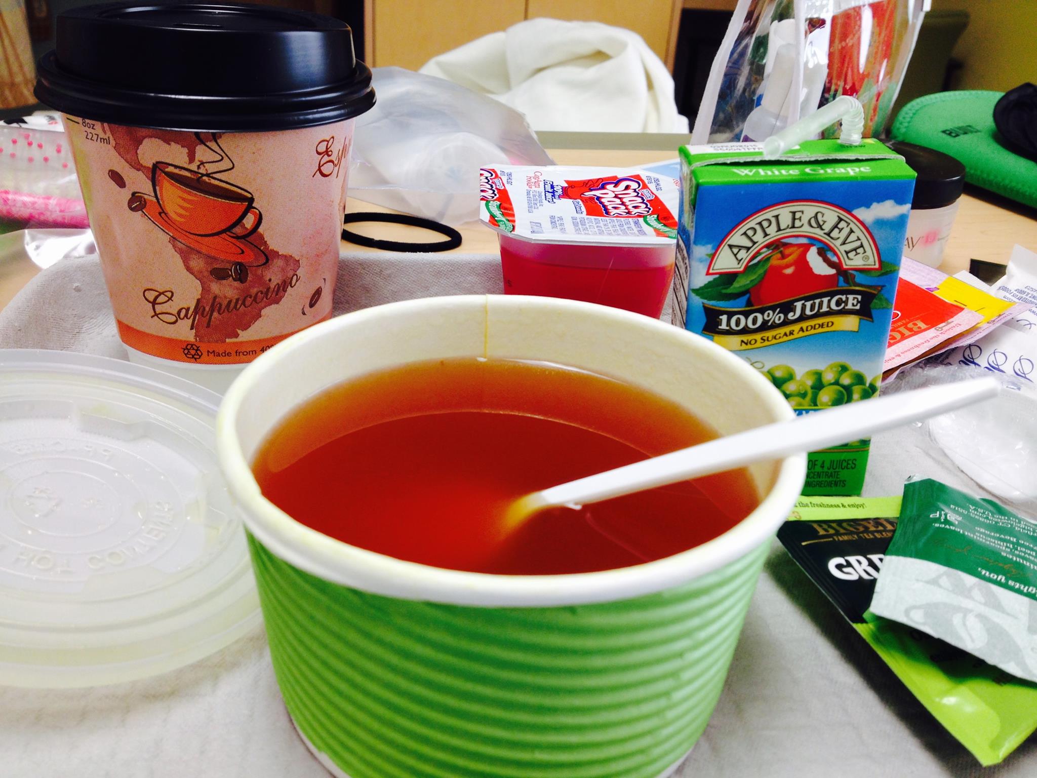 Picture of broth in a take away container, a box of apple juice, jello, and a to-go coffee cup from my first hospitalization. 