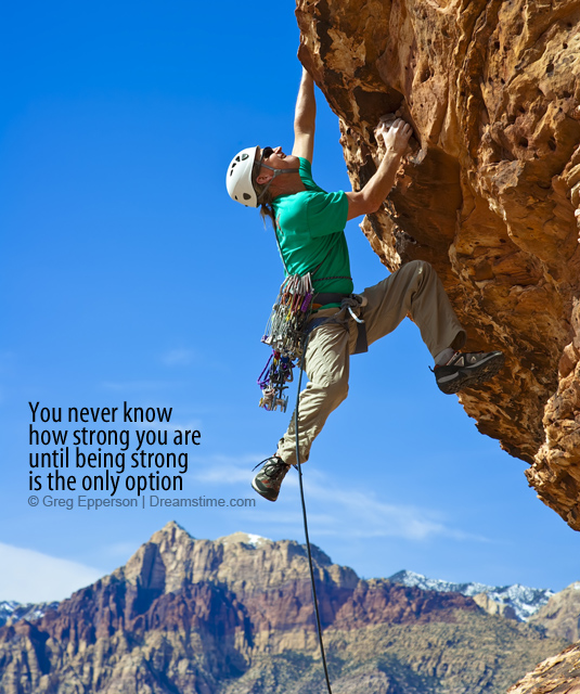 Male rock climber reaching for the summit.