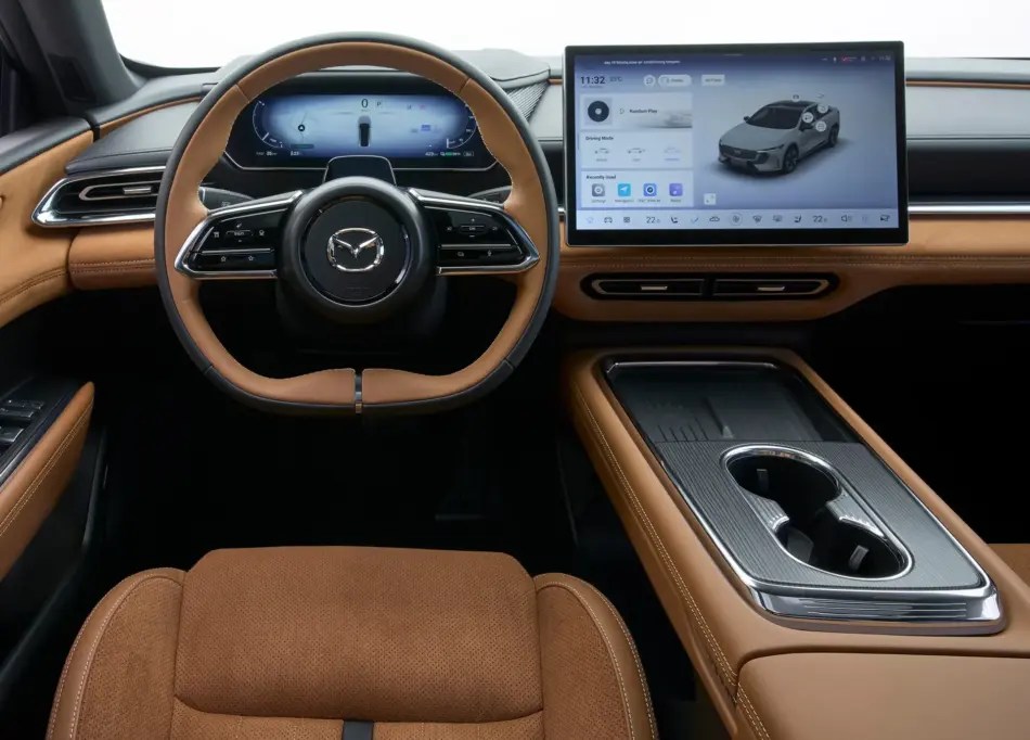 Interior de coche de lujo con asientos y volante de cuero marrón, cuadro de instrumentos digital y una amplia pantalla táctil en el salpicadero