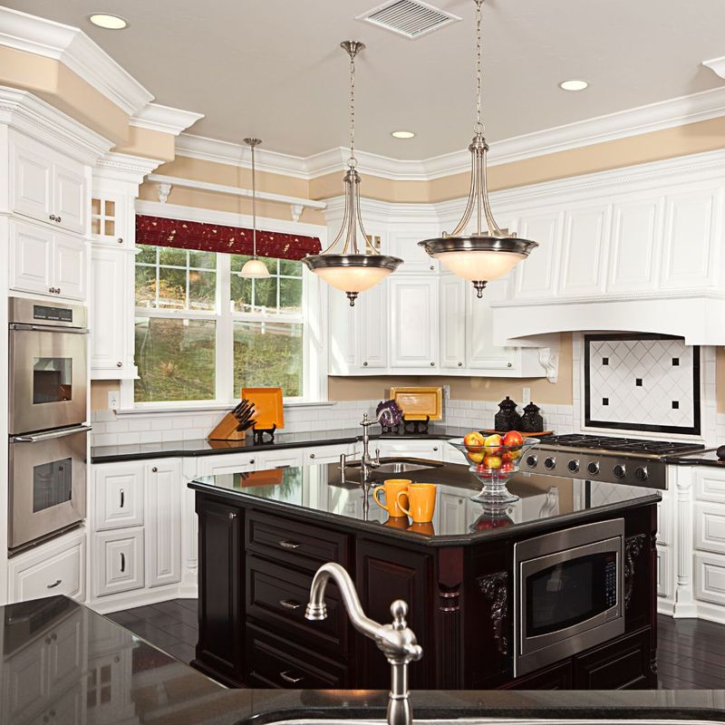 Modern custom kitchen with sleek black countertops, white cabinetry, and stainless steel appliances, creating a striking contrast and contemporary look.