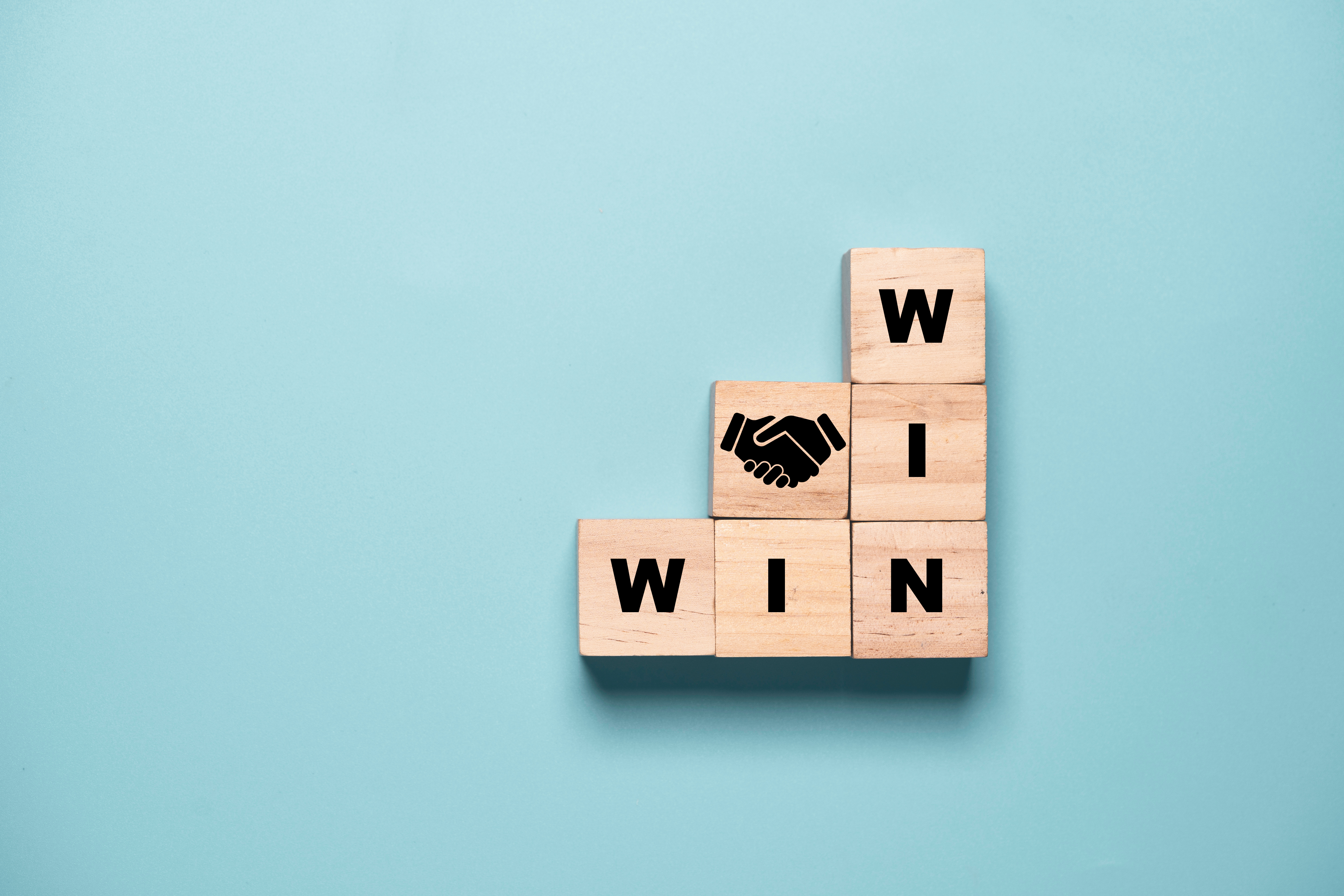 Win win wording with business hand shaking which print screen on wooden cube block , Business deal agreement concept.