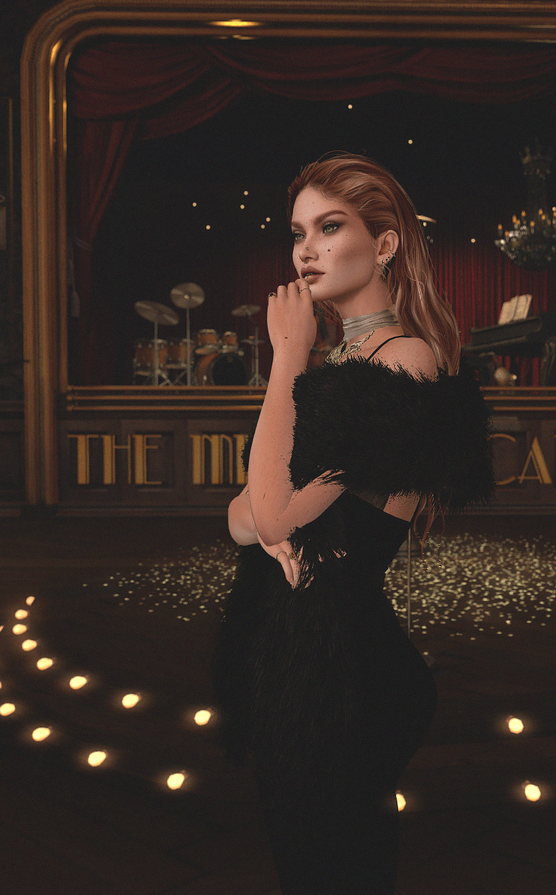 Guest in black evening attire posed before the cabaret stage