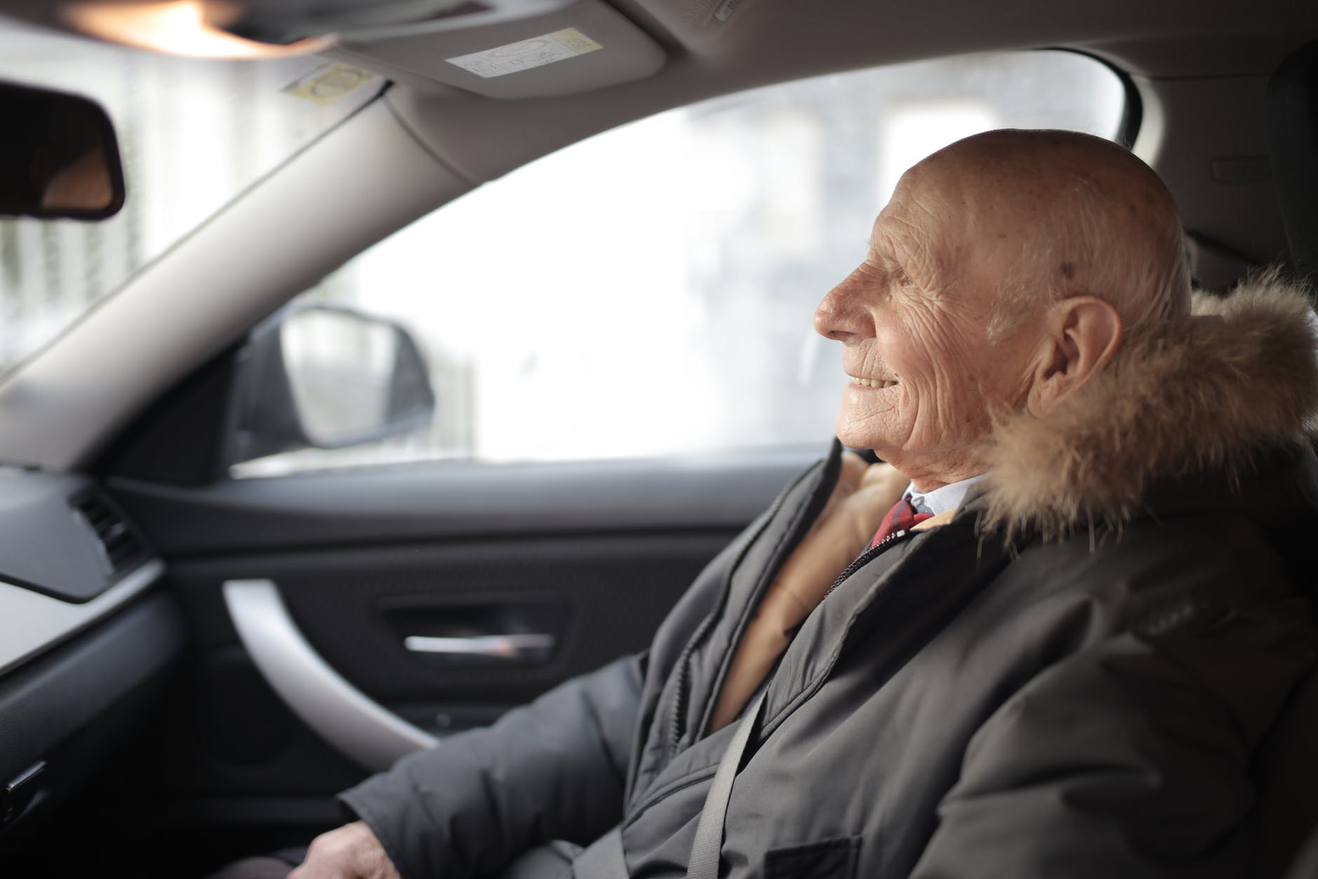 smiling senior man in modern car