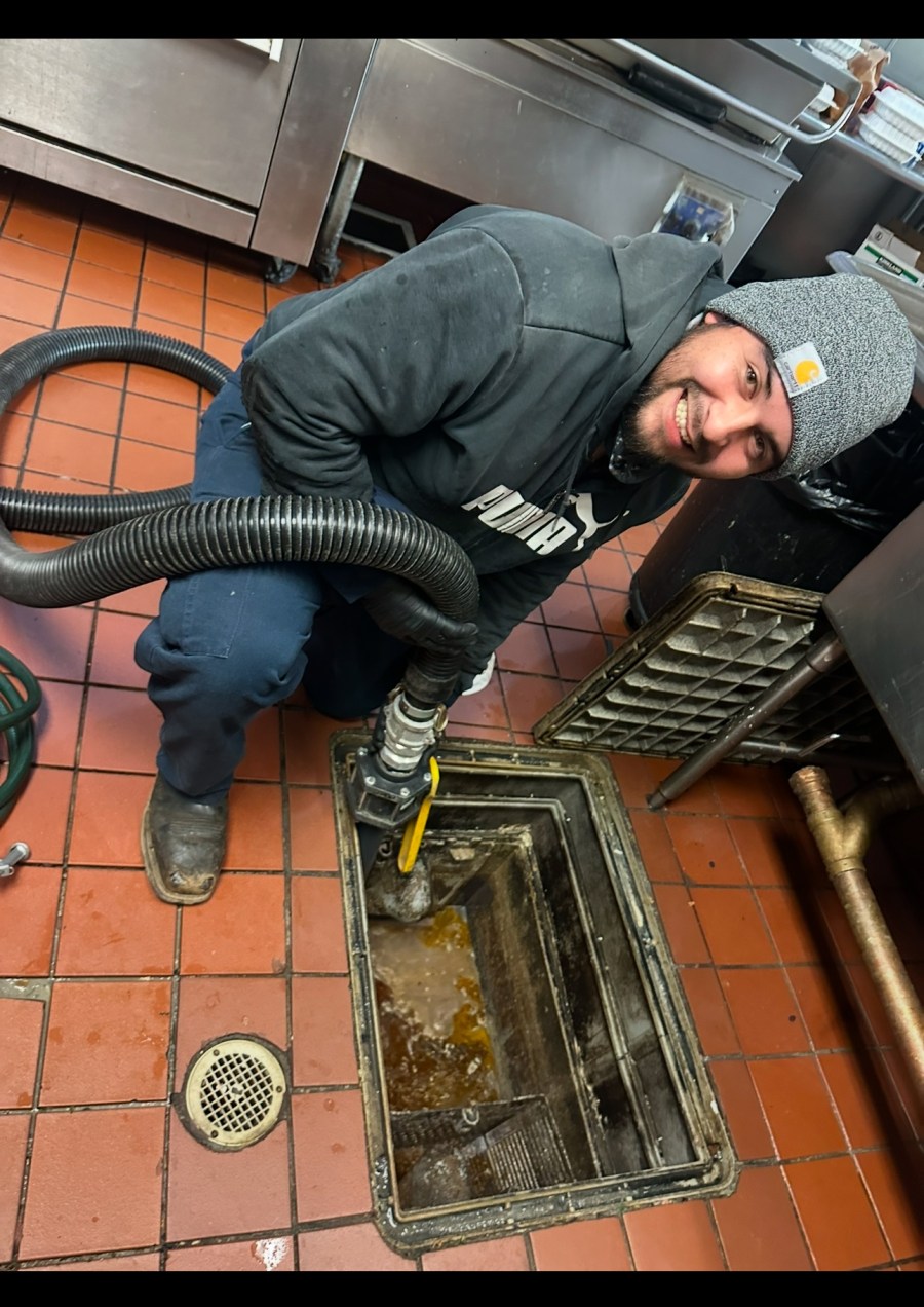 MG Grease technician servicing a restaurant grease trap