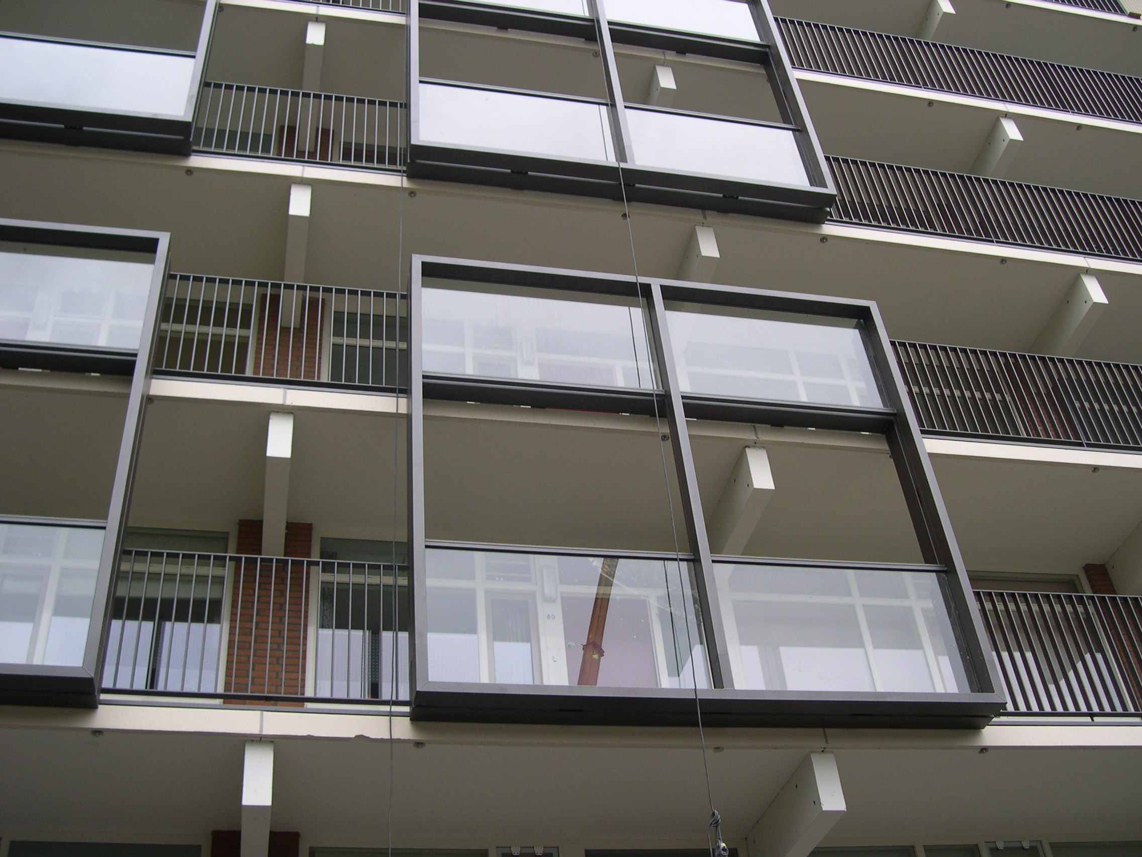 Voorzijde van een flatgebouw met aluminiem profielen die glazen wanden bevatten