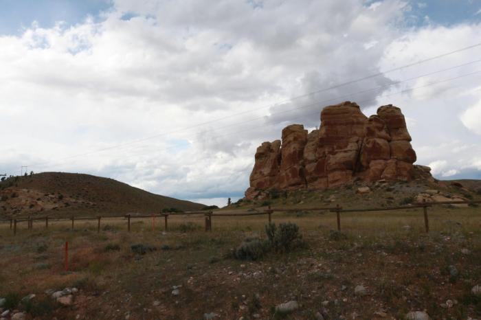 These thrusting boulders are a sharp contrast to the green rolling hills immediately around them.--Southeast of Dubois, WY