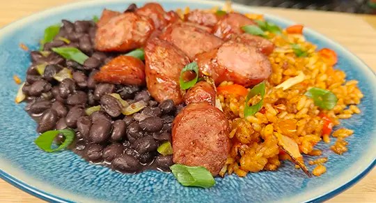 Air fryer smoked sausage, rice, peppers, onions, and black beans served on a blue plate