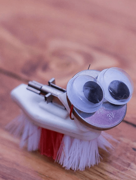 A googly-eyed critter made from a small brush head.