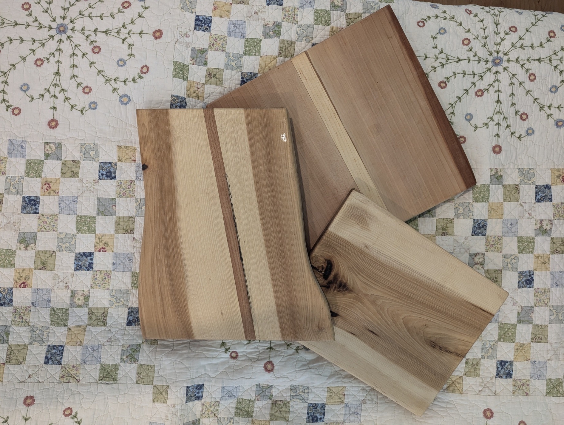 Several cutting boards made from layered and laminated light and dark wood.