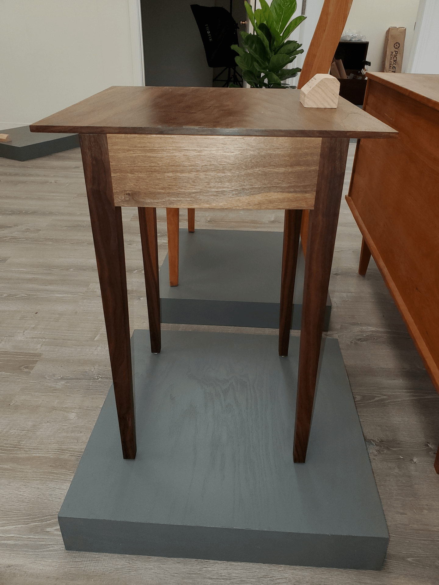 A dark wood modern style square side table.