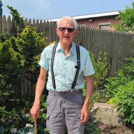 Photo of older man standing in the Museum's Union Street garden. He is a sculptor who had just installed a sculpture he had donated to the Museum.