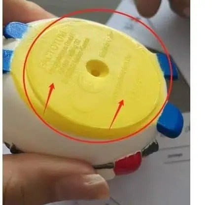 Underside of rubber duck toy showing moulded certification markings checked during Minden Intl quality control inspection