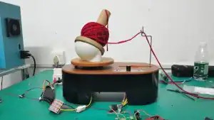 Early electric yarn winder prototype with wood-toned spool holder on factory workbench