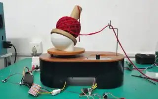 Working prototype of a new electric yarn winder under function test on a factory bench in China, with exposed wiring and control boards