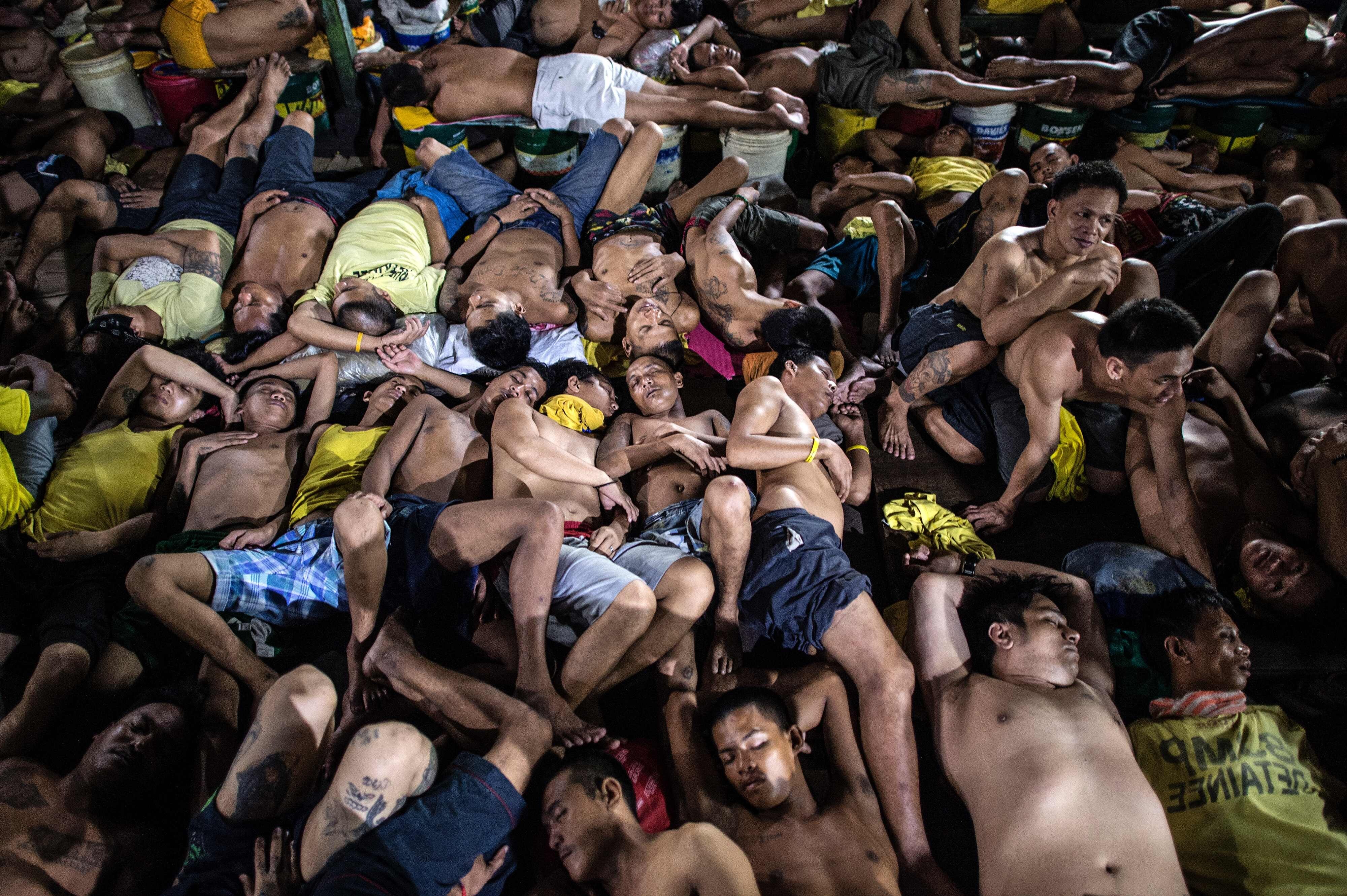 Overcrowded prison in Southeast Asia with inmates packed tightly together, illustrating harsh conditions and lack of space.