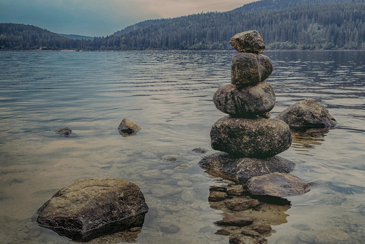 A tower of pebbles in a calm scenic lake to represent balance and serenity