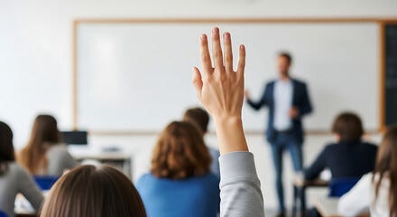 A student in a classroom raises their hand, focusing on the teacher standing before a whiteboard. This represents the type of response we must have as God calls us to the harvest: "Here I am. Send me".