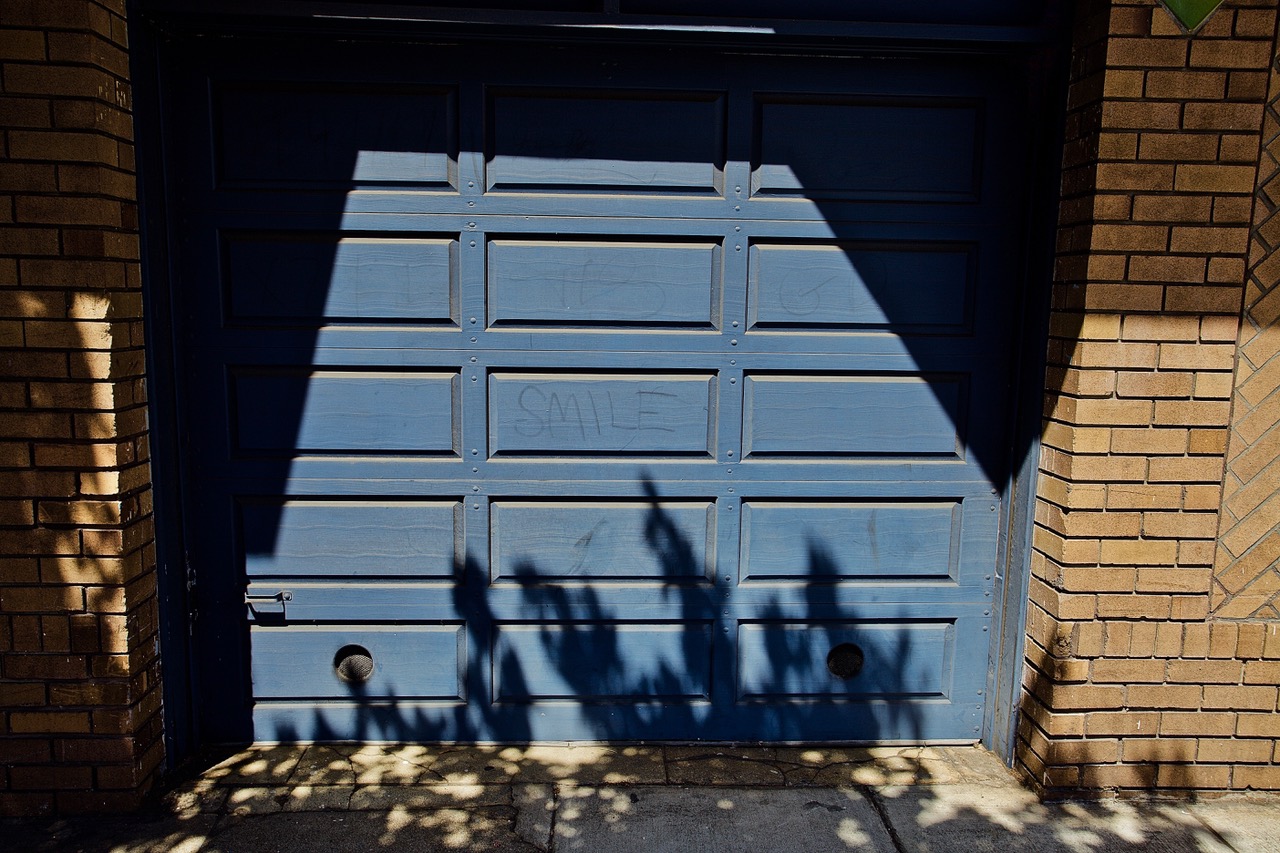 The word smile written on a blue garage door.