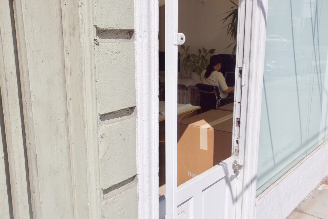An office window cracked open to see a woman at work.