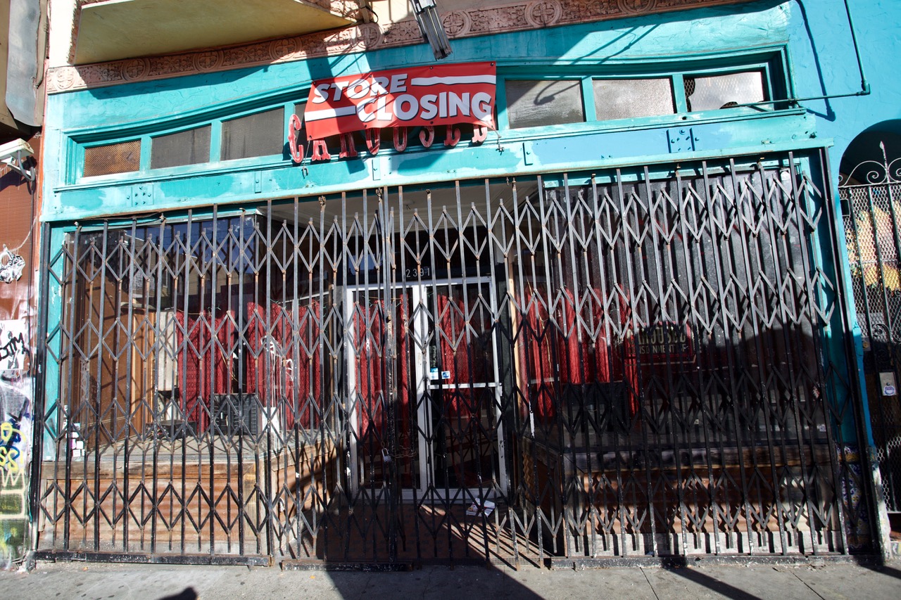 A shuttered storefront with metal gates covering the front.